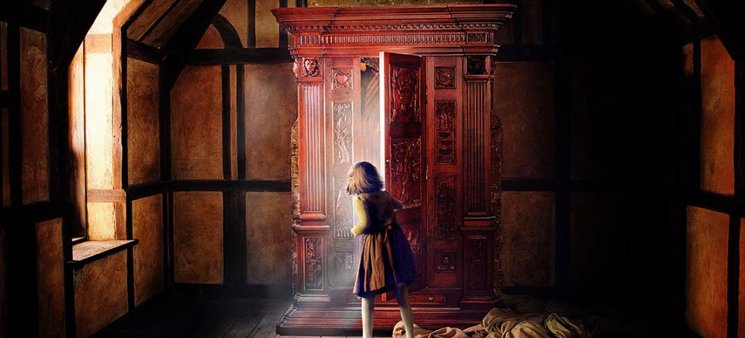 Lucy looks in the wardrobe in The Chronicles Of Narnia Key Art