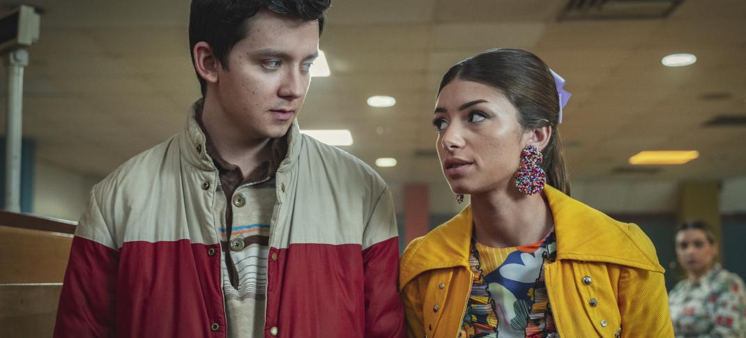 Asa Butterfield as Otis Milburn and Mimi Keene as Ruby Matthews walk together down a school hallway