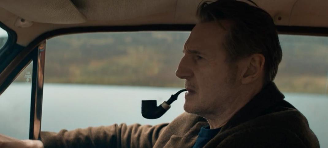 Liam Neeson as Finbar driving, pipe in mouth, in In the Land of Saints and Sinners