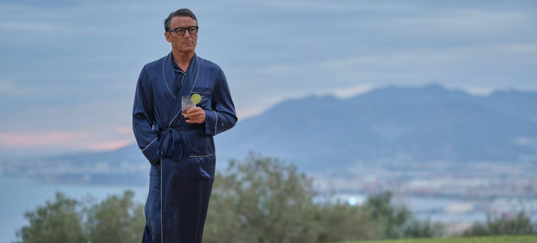 Jason Isaacs as Cary Grant, holding a gin and tonic in his Los Angeles home in 'Archie'