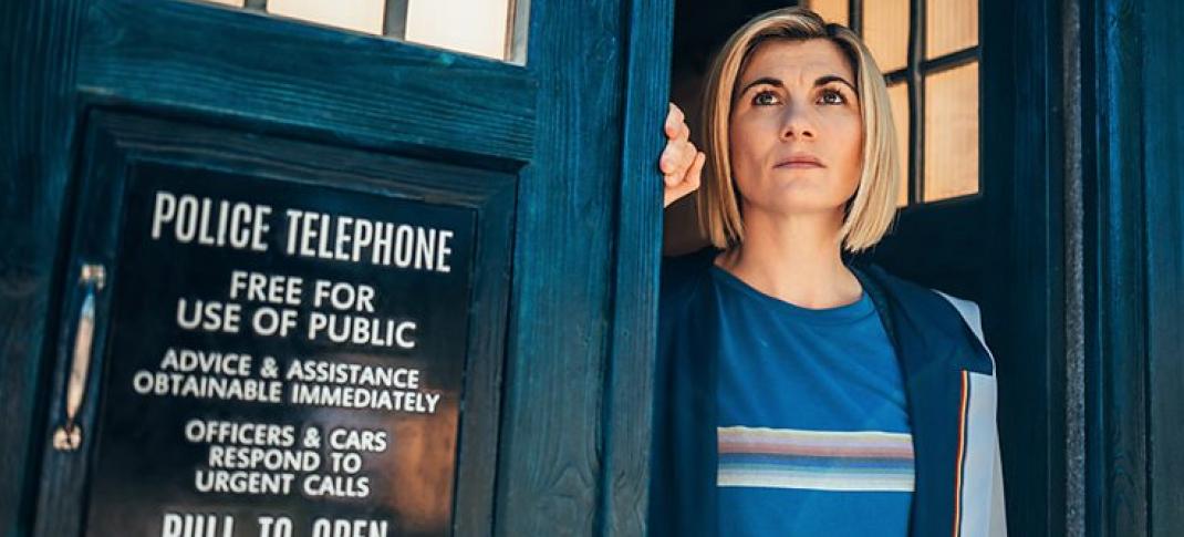 Jodie Whittaker as the 13th Doctor stands in the doorway of the TARDIS