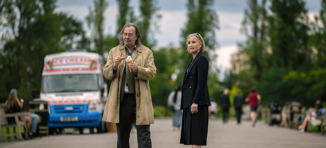 Gary Oldman as Jackson Lamb and Kristin Scott Thomas as Diana Taverner stand by an ice cream truck in the 'Slow Horses' Season 3 finale