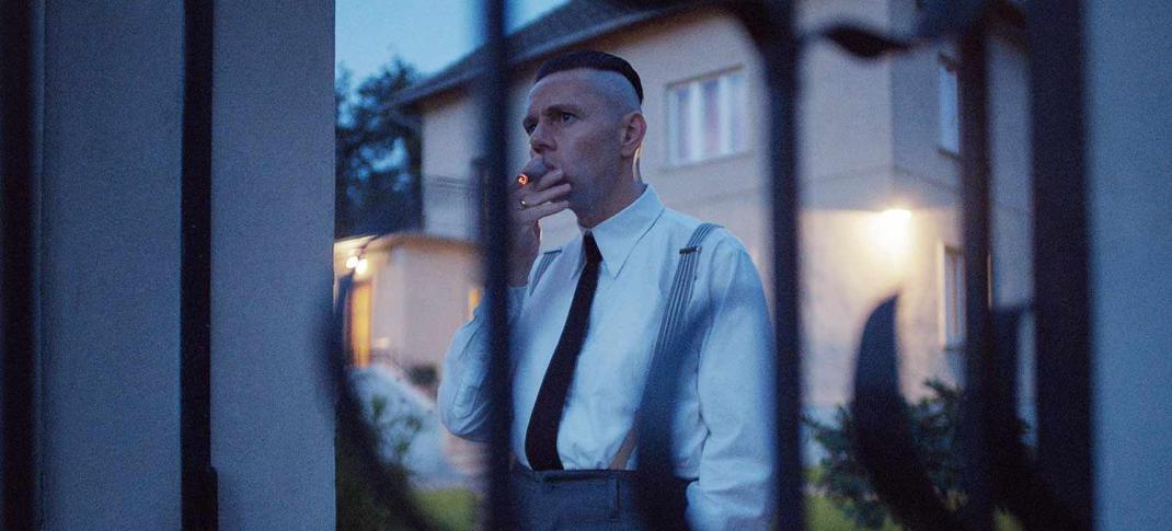 Christian Friedel as Rudolf Höss smokes a cigar in 'The Zone of Interest'