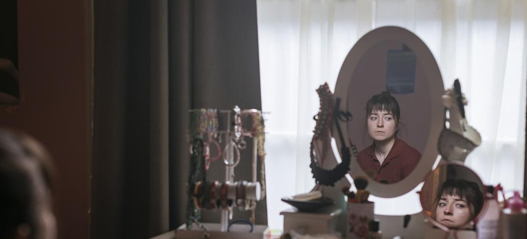 Hazel Doupe as Harper Fenn looks at herself in her vanity mirror in 'Sanctuary: A Witch's Tale' Season 1