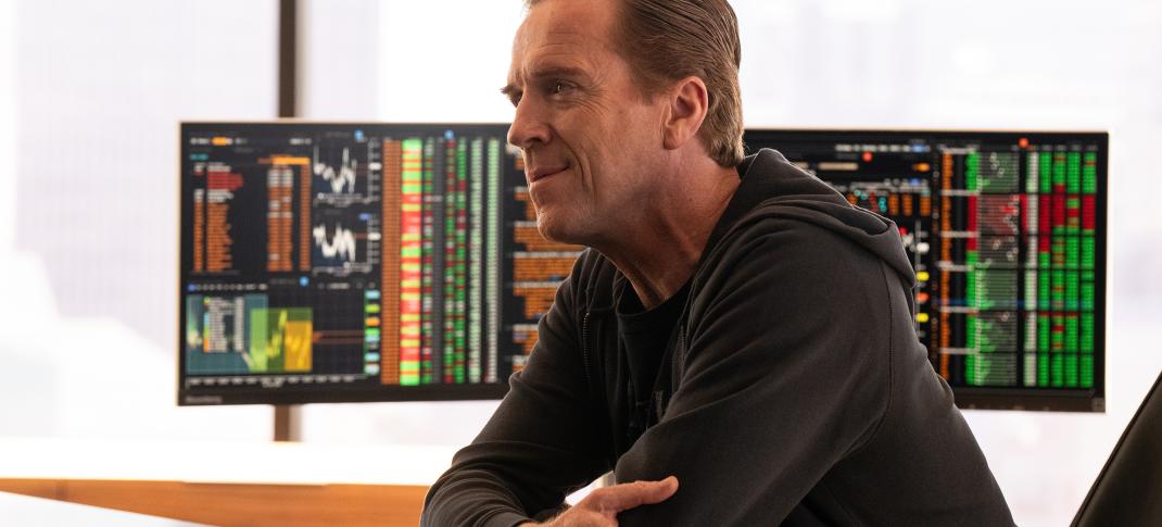 Damian Lewis as Bobby "Axe" Axelrod sitting at his desk looking smug in Billions Season 7