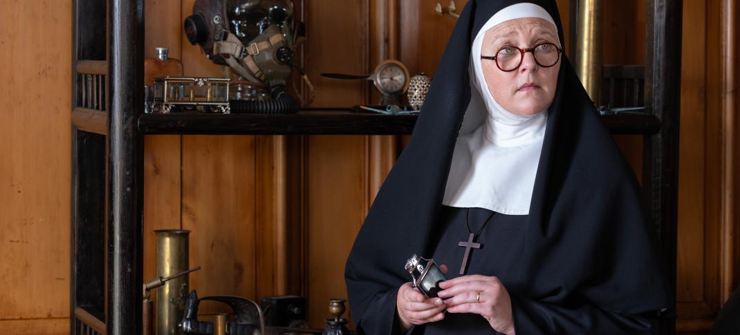 Lorna Watson as Sister Boniface next to a shelf of murder weapons in Sister Boniface Mysteries Season 3