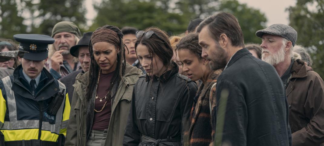 Seán Óg Cairns as Garda Eoin, Kerri McLean as Maeve, Siobhán Cullen as Dove, Robyn Cara as Emmy Sizergh, and Will Forte as Gilbert Power stand over a dead body in 'Bodkin'