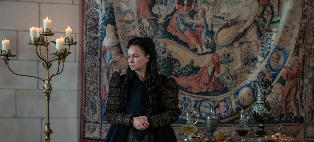 Catherine de Medici (Samantha Morton) poses by candlelight in front of a tapestry