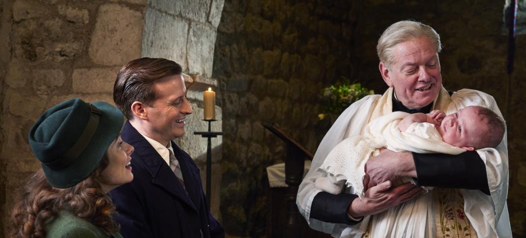 Picture shows: Baby Jimmy's christening. Helen Herriott (Rachel Shenton) and James Herriot (Nicholas Ralph) watch as the Vicar (Mark Chatterton) prepares to baptize their baby son.