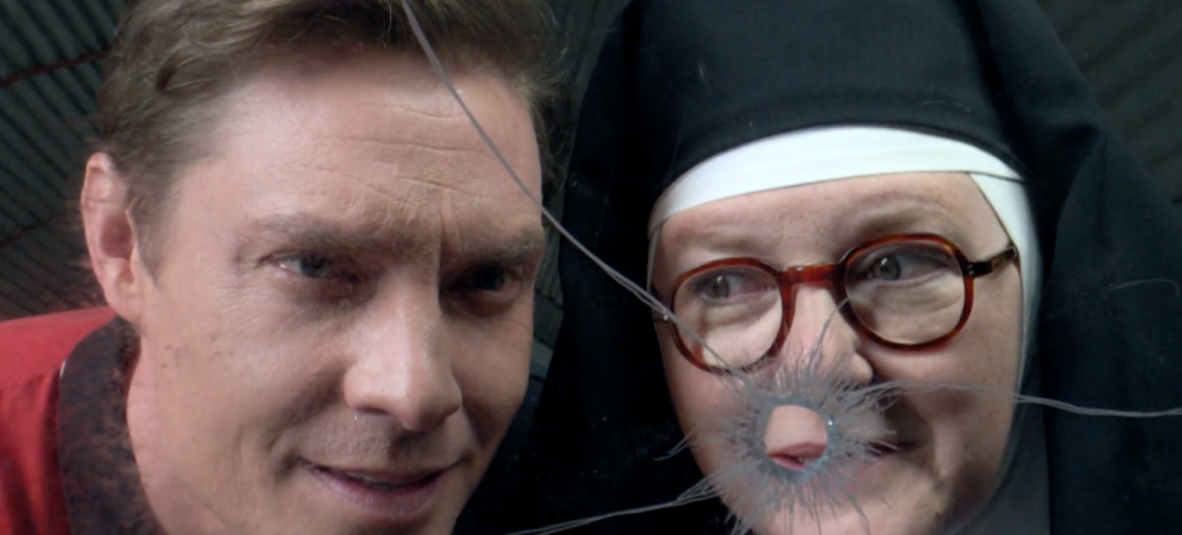 Picture shows: Sister Boniface (Lorna Watson and DI Sam Gillespie (Max Brown) peer through a window with a bullet hole.