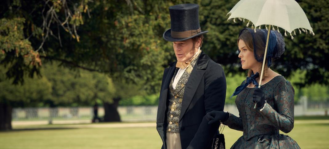 Richard Goulding and Alice Eve as Oliver and Susan Trenchard walk arm in arm through the parkin 'Belgravia' Season 1