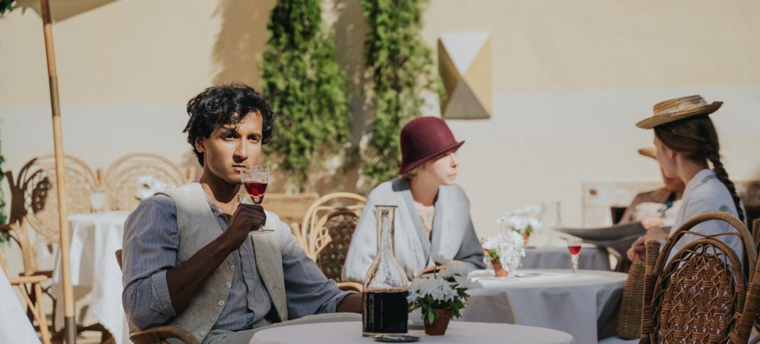 Assad Zaman as Anish Sengupta drinks and contemplates in 'Hotel Portofino' Season 1