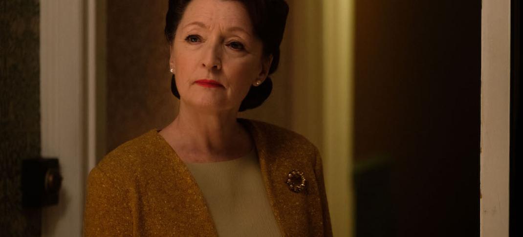 Lesley Manville as Robina Chase stands in a hallway in World on Fire Season 1