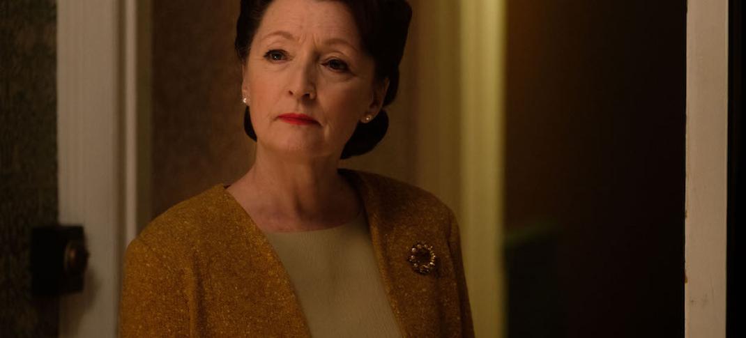 Lesley Manville as Robina Chase stands in a hallway in World on Fire Season 1